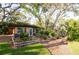 Landscaped backyard with a wooden shed, flourishing garden, and mature shade trees at 1880 Belleair Rd, Clearwater, FL 33764