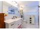 Bathroom with a modern vanity with a white countertop, a decorative mirror, and light blue walls at 1880 Belleair Rd, Clearwater, FL 33764