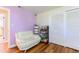 Bedroom featuring a comfortable white chair, purple accent wall, closet, and wood floor at 1880 Belleair Rd, Clearwater, FL 33764