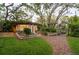 Charming cabin with inviting curb appeal, surrounded by manicured landscaping and a delightful treehouse at 1880 Belleair Rd, Clearwater, FL 33764