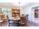 Traditional dining room features an oval wood table, charming china cabinet, and natural light from the window at 1880 Belleair Rd, Clearwater, FL 33764