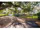 A charming home with mature trees, a spacious driveway, and inviting outdoor seating at 1880 Belleair Rd, Clearwater, FL 33764