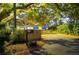 Private driveway leads to a charming blue home surrounded by beautiful mature trees and lush landscaping at 1880 Belleair Rd, Clearwater, FL 33764