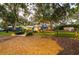 Charming single-story home with blue exterior, mature trees and a fenced yard at 1880 Belleair Rd, Clearwater, FL 33764