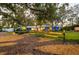 Charming home with inviting outdoor patio, enveloped by mature trees and a spacious landscaped yard at 1880 Belleair Rd, Clearwater, FL 33764