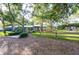 Charming home with vibrant blue exterior, beautiful landscaping, mature trees and a quaint wooden fence at 1880 Belleair Rd, Clearwater, FL 33764