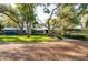 Charming home with a well-manicured lawn and lush landscaping, framed by mature trees at 1880 Belleair Rd, Clearwater, FL 33764