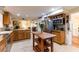 An open kitchen with an island, stainless appliances, custom cabinets, and a dining area nearby at 1880 Belleair Rd, Clearwater, FL 33764