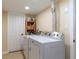 Well-lit laundry room with new washer and dryer, complemented by shelving for supplies at 1880 Belleair Rd, Clearwater, FL 33764