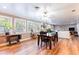 Open-concept living room with a dining table, natural light, hardwood floors, and a view of the outside at 1880 Belleair Rd, Clearwater, FL 33764