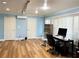 Bright office featuring hardwood floors, a large window with blinds, and two closets for storage at 1880 Belleair Rd, Clearwater, FL 33764