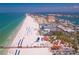 Expansive aerial view of a beachfront community with pristine white sand, turquoise waters, and various amenities at 211 Dolphin Pt # 403, Clearwater Beach, FL 33767