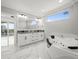 Primary bathroom with double vanity, a soaking tub, and access to a balcony at 211 Dolphin Pt # 403, Clearwater Beach, FL 33767