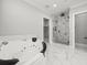 Luxurious bathroom with soaking tub and a glass-enclosed shower with a marble wall at 211 Dolphin Pt # 403, Clearwater Beach, FL 33767