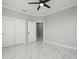 Spacious bedroom with modern ceiling fan, closet, and sleek marble flooring at 211 Dolphin Pt # 403, Clearwater Beach, FL 33767
