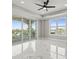 Bright bedroom featuring tray ceiling, marble floors, and balcony access at 211 Dolphin Pt # 403, Clearwater Beach, FL 33767