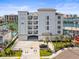 Coastal building featuring private balconies, covered parking, and lush landscaping with city views in the background at 211 Dolphin Pt # 403, Clearwater Beach, FL 33767