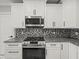 Kitchen featuring modern cabinetry, stainless steel appliances, and backsplash with designer backsplash at 211 Dolphin Pt # 403, Clearwater Beach, FL 33767
