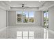 Bright living room with large windows and a ceiling fan at 211 Dolphin Pt # 403, Clearwater Beach, FL 33767