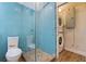 Bathroom features striking blue tile, glass shower and a convenient stacked washer and dryer at 233 45Th Ave, St Pete Beach, FL 33706