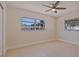 Bright bedroom featuring neutral walls, tile floors, a ceiling fan and lots of natural light through large windows at 233 45Th Ave, St Pete Beach, FL 33706