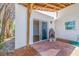 Covered patio with brick flooring, a vintage fireplace, and sliding glass doors to the home's interior at 233 45Th Ave, St Pete Beach, FL 33706