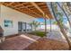 Inviting covered outdoor patio with paver flooring, wooden beams, privacy fence, and artificial grass at 233 45Th Ave, St Pete Beach, FL 33706
