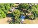 Aerial view highlighting the home nestled among mature trees, outdoor fire pit, shed, and serene surroundings at 27477 Old Trilby Rd, Brooksville, FL 34602
