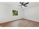 Bright bedroom with wood-look flooring and a backyard view at 27477 Old Trilby Rd, Brooksville, FL 34602