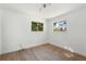Minimalist bedroom featuring wood floors and dual windows for ample natural light at 27477 Old Trilby Rd, Brooksville, FL 34602