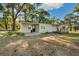 Exterior of home featuring a porch and paved walkway, set against a backdrop of lush greenery at 27477 Old Trilby Rd, Brooksville, FL 34602