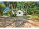 Well-maintained home exterior with a clean white facade and natural landscaping at 27477 Old Trilby Rd, Brooksville, FL 34602