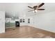 Bright living room with wood-look flooring, ceiling fan, and a view of the kitchen at 27477 Old Trilby Rd, Brooksville, FL 34602
