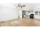 Open-concept living space with wood-look flooring, ceiling fan, and view of the kitchen at 27477 Old Trilby Rd, Brooksville, FL 34602