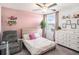 Light-filled bedroom with floral bedding and pink accent wall at 2870 Silver Scallop Dr, Wimauma, FL 33598