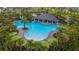 Aerial view of the community pool surrounded by lounge chairs, cabanas, and palm trees at 2870 Silver Scallop Dr, Wimauma, FL 33598