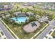 Aerial view showcasing a community pool, playground, and green spaces for resident enjoyment at 2870 Silver Scallop Dr, Wimauma, FL 33598