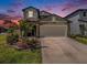 Charming two-story home featuring a well-maintained lawn, landscaped flower beds, and a two-car garage at 2870 Silver Scallop Dr, Wimauma, FL 33598