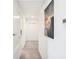 Bright hallway with neutral carpet, white trim, and artwork on the wall at 2870 Silver Scallop Dr, Wimauma, FL 33598