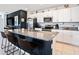 A kitchen features white cabinets, stainless steel appliances, and a granite countertop island with seating at 2870 Silver Scallop Dr, Wimauma, FL 33598
