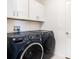 A laundry room with front load washer and dryer and overhead cabinets for storage at 2870 Silver Scallop Dr, Wimauma, FL 33598