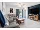 Cozy living room with gray leather sofa, wood entertainment center, and sliding glass doors to the outside at 2870 Silver Scallop Dr, Wimauma, FL 33598