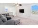 Bright living room featuring plush gray sectional sofa, and a ceiling fan at 2870 Silver Scallop Dr, Wimauma, FL 33598