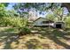 View of backyard featuring a lush green lawn, large shade trees, and storage shed at 29133 Lawton Dr, Nobleton, FL 34661