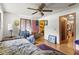Well-lit bedroom with hardwood floors, a ceiling fan, and a view of an ensuite bathroom at 29133 Lawton Dr, Nobleton, FL 34661
