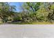 Inviting property showcasing a well-kept lawn, mature trees, and traditional home design at 29133 Lawton Dr, Nobleton, FL 34661