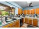 Well-lit kitchen area featuring wood cabinets, black appliances, and a window view at 29133 Lawton Dr, Nobleton, FL 34661