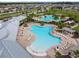 Aerial view of neighborhood pools, clubhouse, and residences surrounded by palm trees and lush greenery at 3065 Living Coral Dr, Odessa, FL 33556