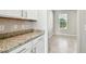 Dining area showcasing elegant granite countertops, white cabinets, and a window providing great natural light at 3065 Living Coral Dr, Odessa, FL 33556