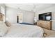 This main bedroom is bright and spacious with a scenic view and a large TV at 3065 Living Coral Dr, Odessa, FL 33556
